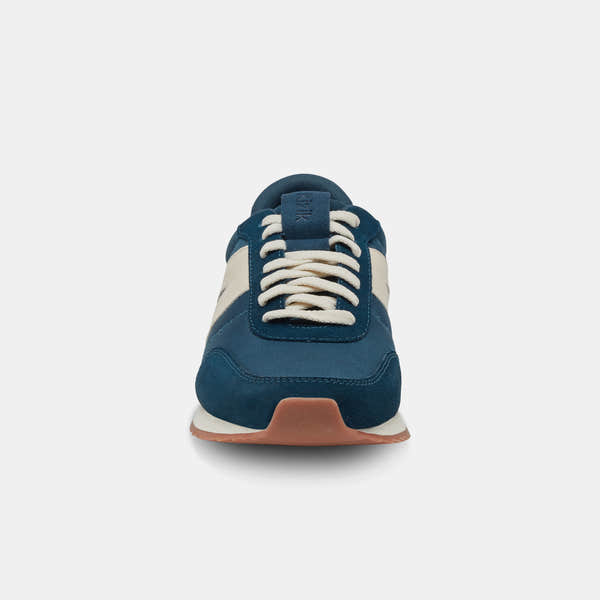 Kizik Milan unisex slip-on trainers in tidepool leather and textile with arch support, white laces, and beige and navy accents.