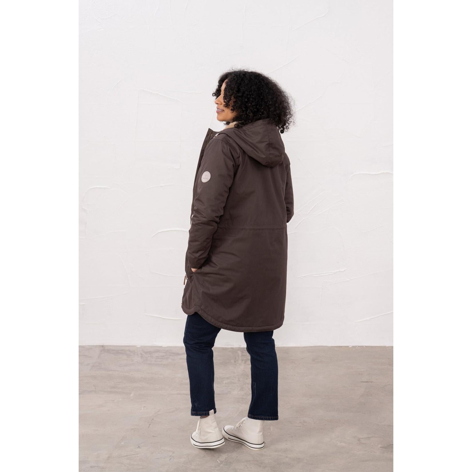 Lighthouse Isobel Cocoa women's padded waterproof coat with hood, fitted design, and white sneakers.