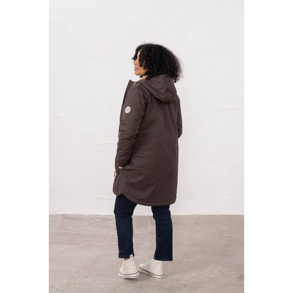 Lighthouse Isobel Cocoa women's padded waterproof coat with hood, fitted design, and white sneakers.