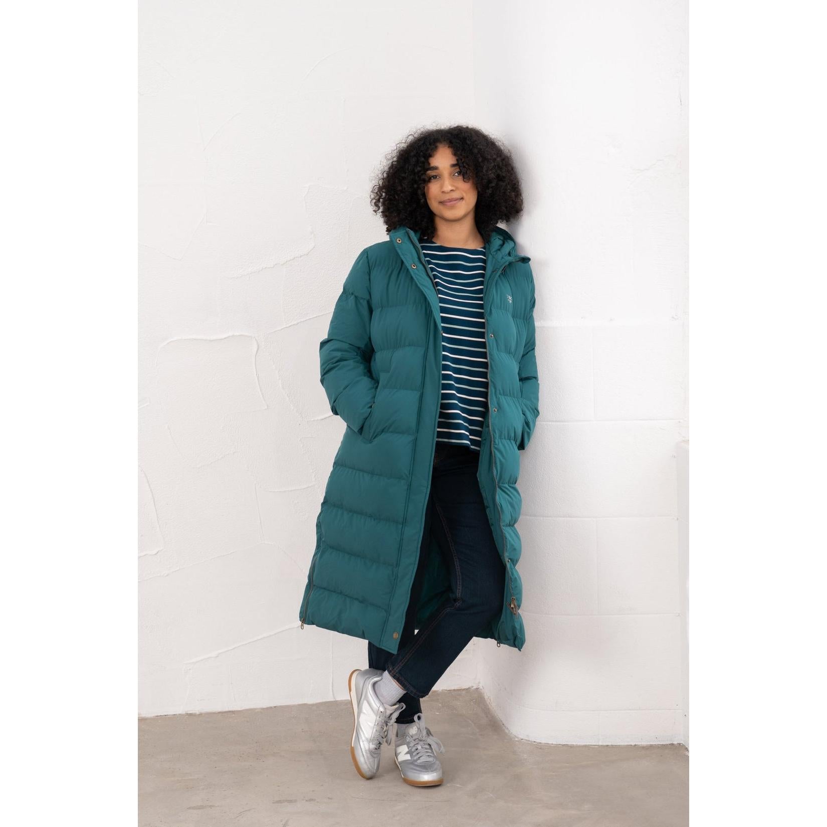Lighthouse Savannah Pine women's puffer coat in teal with hood, worn over striped top, dark jeans, and sneakers.