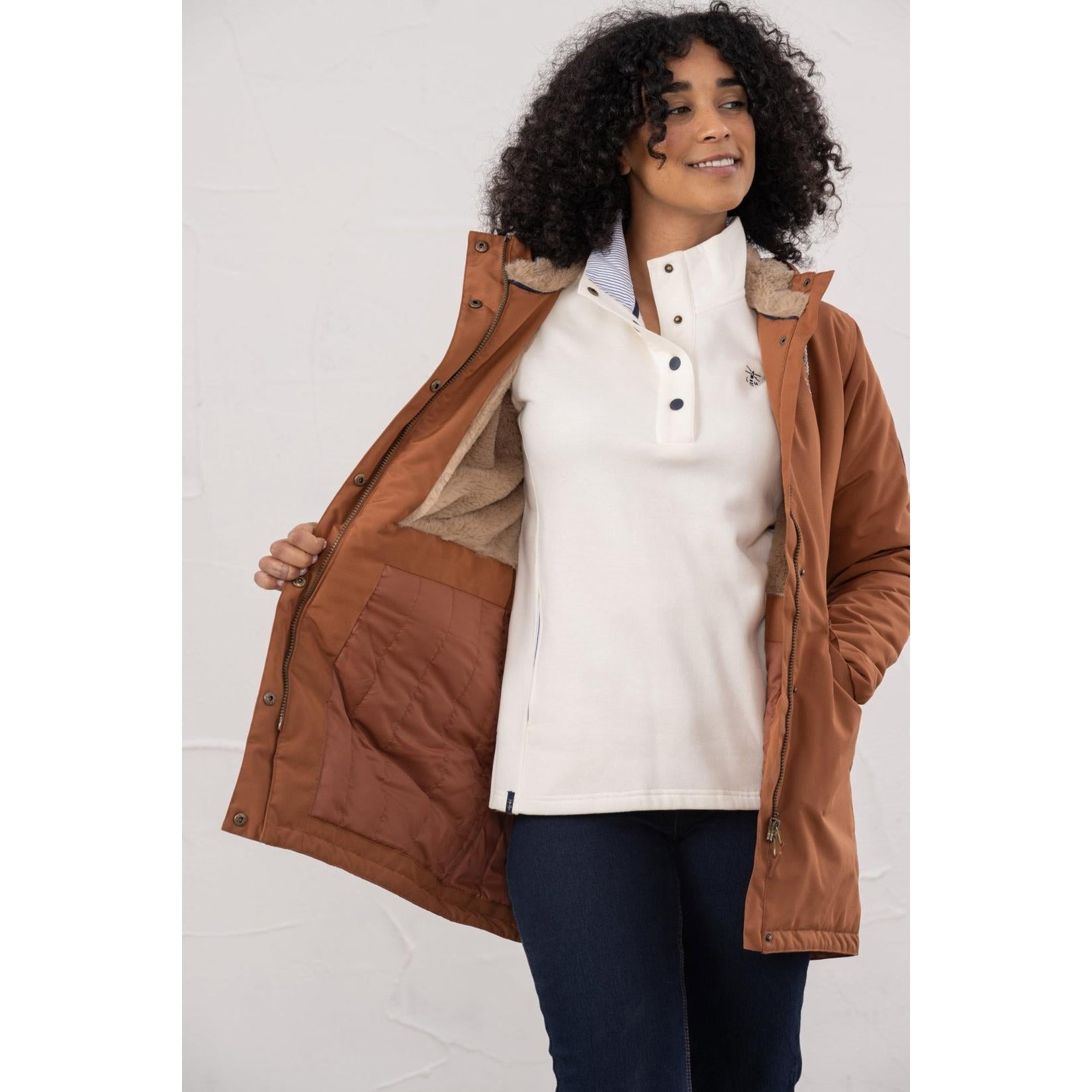 Lighthouse Scarlet Ladies Waterproof Coat in Rust color, featuring cozy lining, high collar, and zipper closure, ideal for rainy weather.