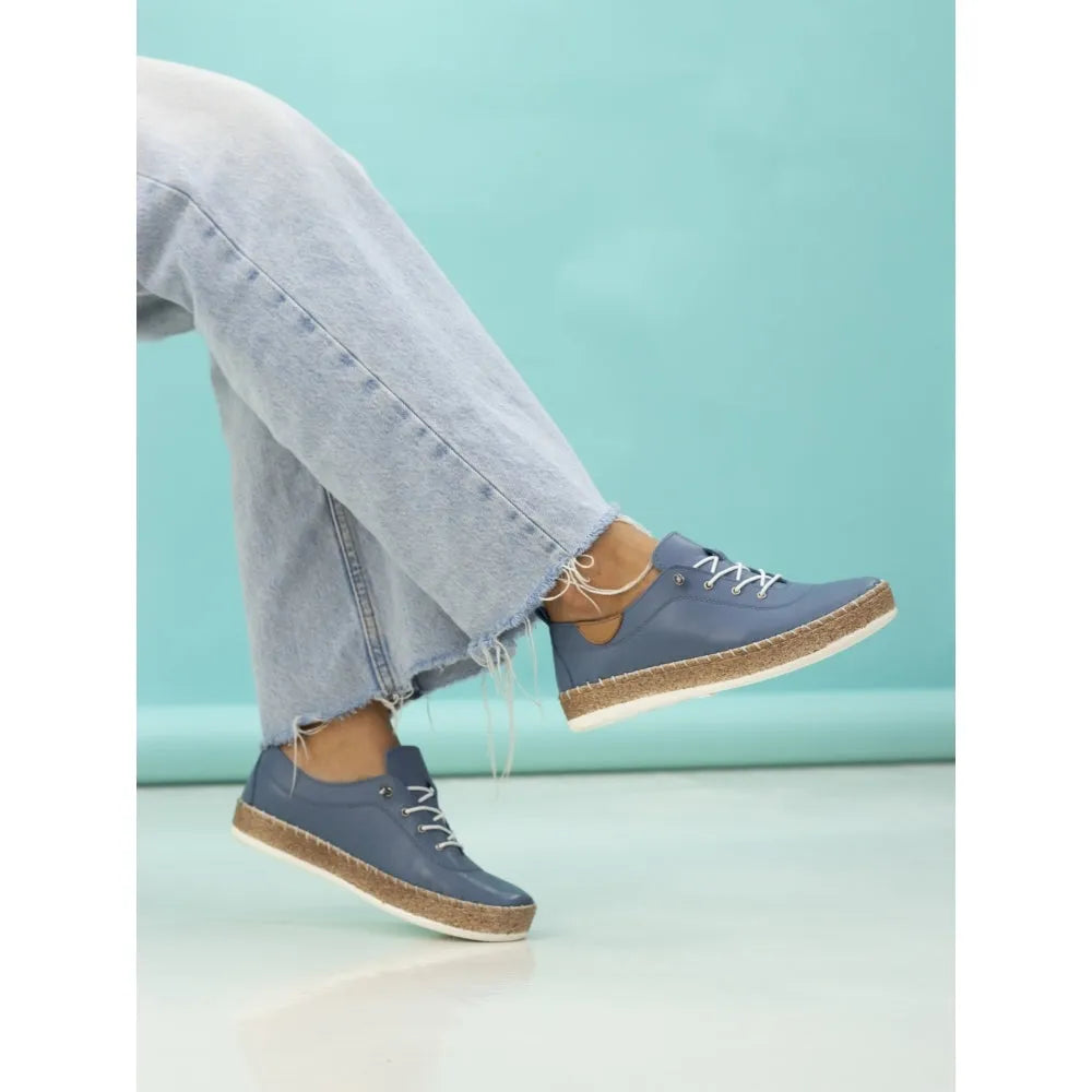 Lunar FLE050 Evie Ladies Mid Blue Leather Elasticated Shoes with a cork and white sole, paired with frayed light-wash jeans.