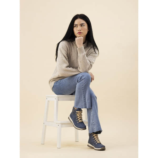 Lunar GLB132 Jett Mid Blue Ladies Waterproof Boot with tan laces, rugged sole, and mid-height design, worn by a woman in casual outfit.