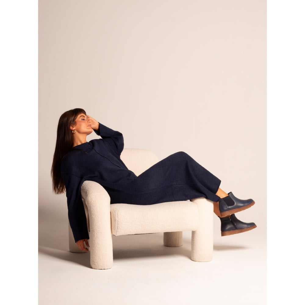 Lunar GLR127 Georgie Ladies Navy Leather Side Zip Ankle Boots with chunky soles, paired with navy knit jumpsuit on model sitting on cream textured armchair.