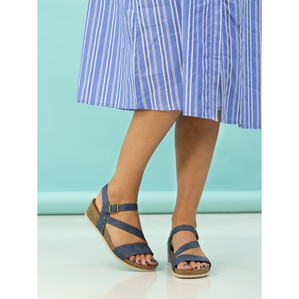 Lunar JLH358 Cluster Ladies Navy Buckle Sandals with straps and cork wedge sole, worn with a blue striped skirt.
