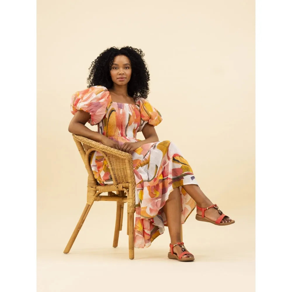 Lunar JLH475 Brava Ladies Orange Elasticated Sandals with ankle straps, worn by a woman in floral dress sitting on wicker chair.