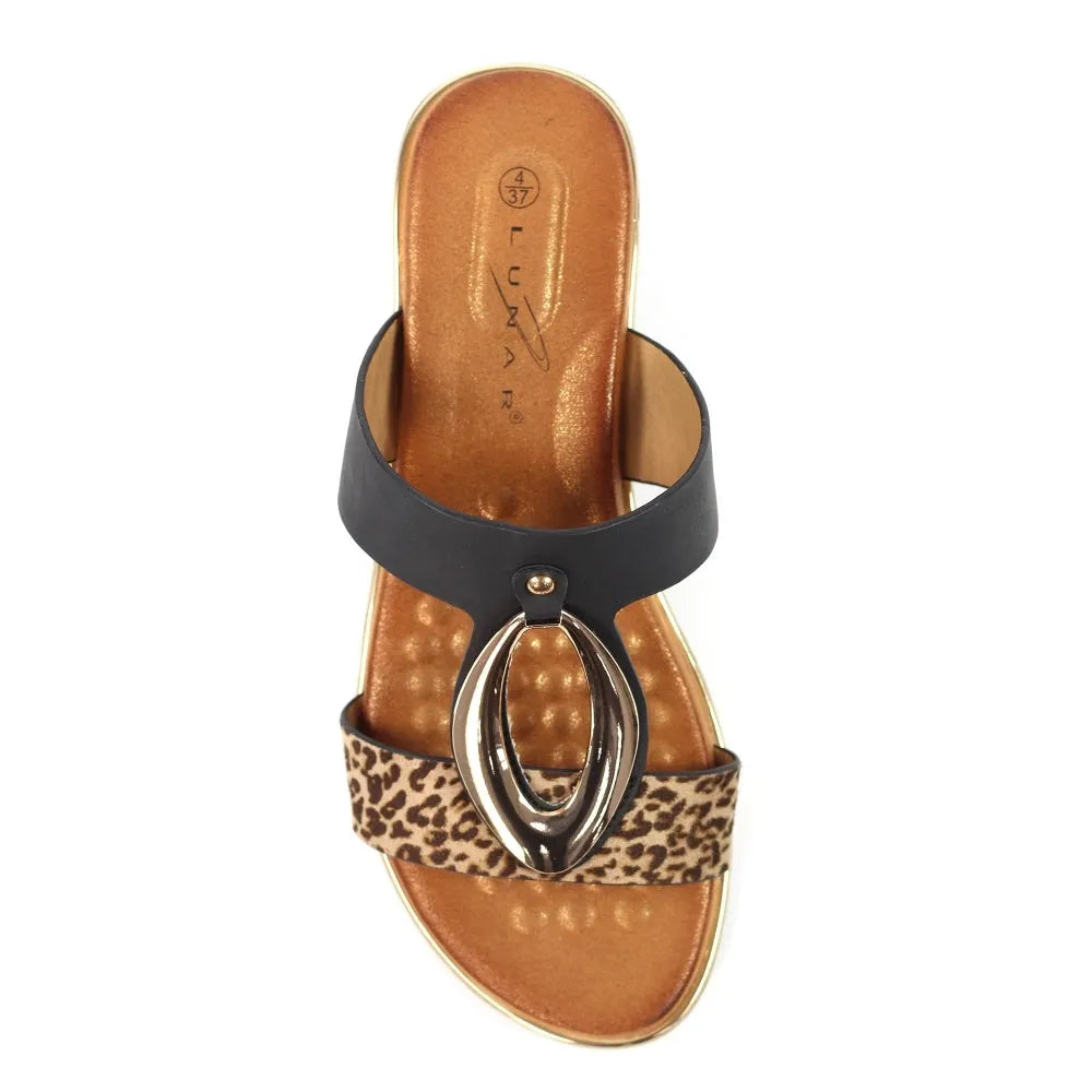 Black slip-on mule with leopard print strap, metallic oval embellishment, and tan insole.
