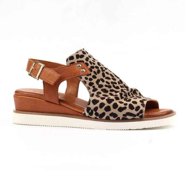 Ocelot-print leather sandals with a brown buckle strap and a cushioned wedge sole, perfect for stylish comfort.