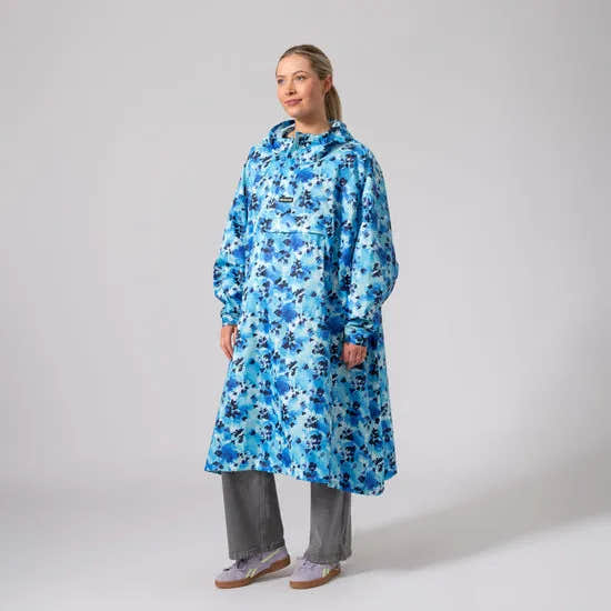 Unisex blue floral festival poncho, waterproof raincoat with hood, oversized fit, worn by woman, casual outdoor rainwear.