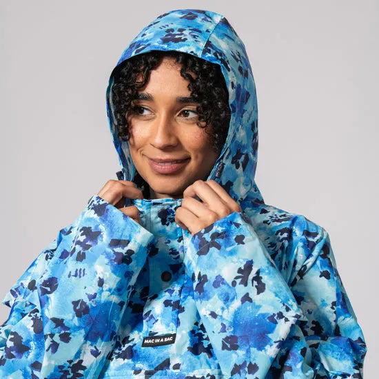 Unisex festival poncho in blue daze camouflage pattern with hood, waterproof fabric, and adjustable front for outdoor rain protection.