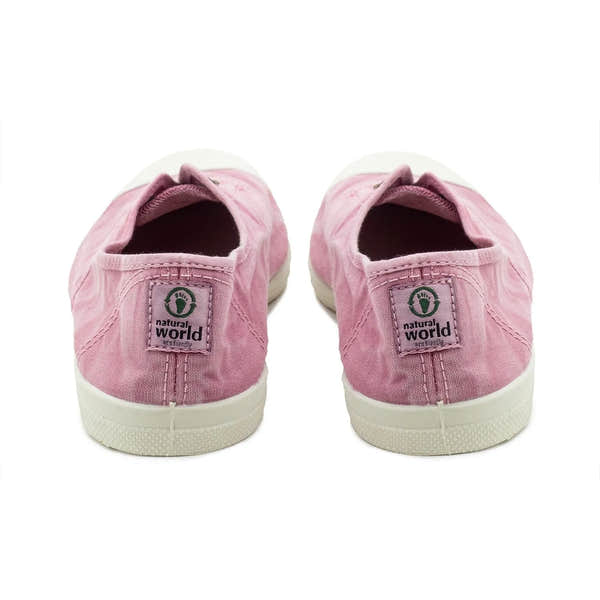 Pink vegan slip-on shoes for women with natural world logo on back strap, fabric upper, and white rubber sole.