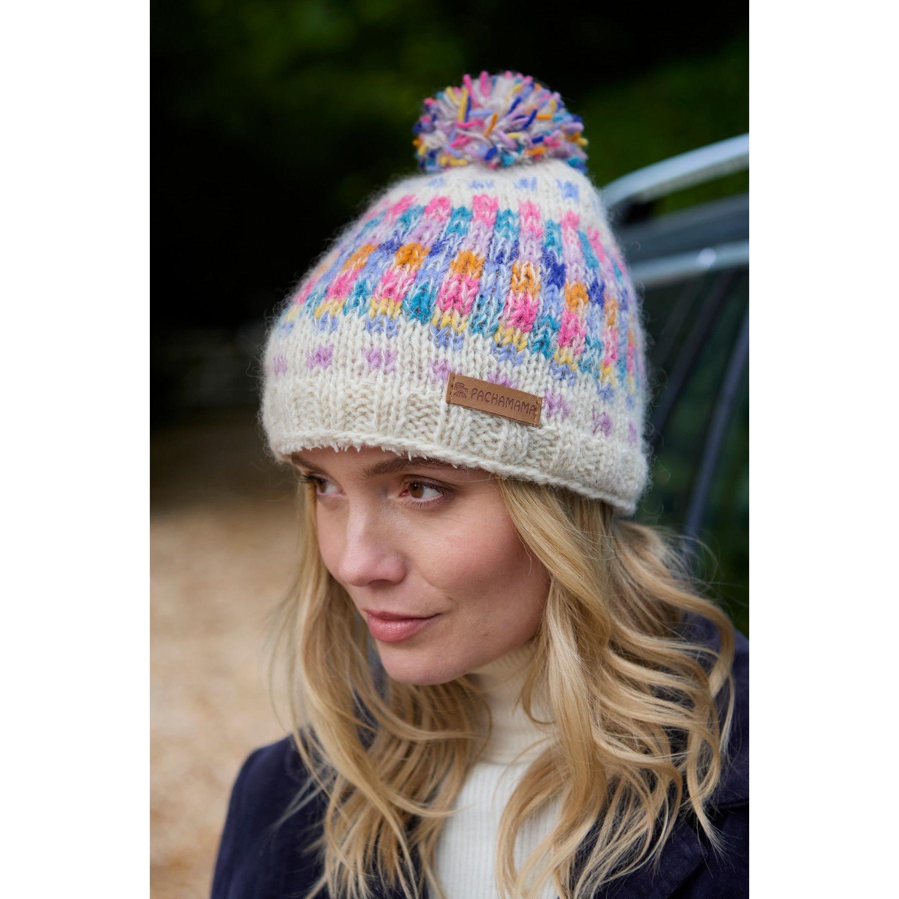 Pachamama Arundel Bobble Beanie in oatmeal with colorful multicolor pom-pom, cozy knit design, and leather logo patch.
