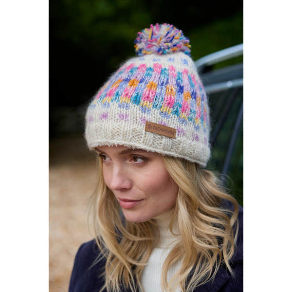 Pachamama Arundel Bobble Beanie in oatmeal with colorful multicolor pom-pom, cozy knit design, and leather logo patch.