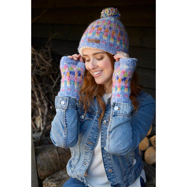 Pachamama Arundel Bobble Beanie Sky with colorful knit pattern, model wearing matching knit gloves and denim jacket.