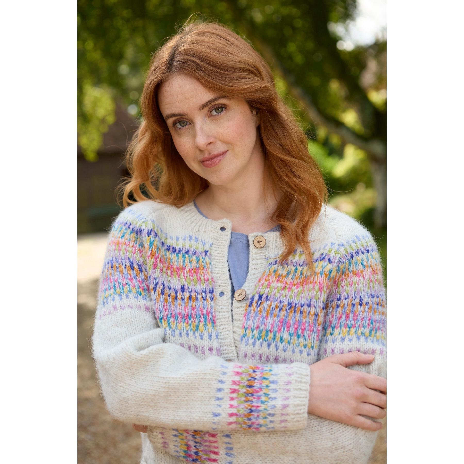 Pachamama Arundel Cardigan in Oatmeal, cozy multicolor knit sweater with wooden buttons, worn by woman outdoors.
