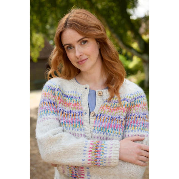 Pachamama Arundel Cardigan in Oatmeal, cozy multicolor knit sweater with wooden buttons, worn by woman outdoors.