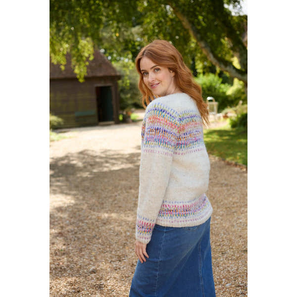 Pachamama Arundel Cardigan in oatmeal with colorful patterned accents, worn by a woman outdoors in a nature setting.