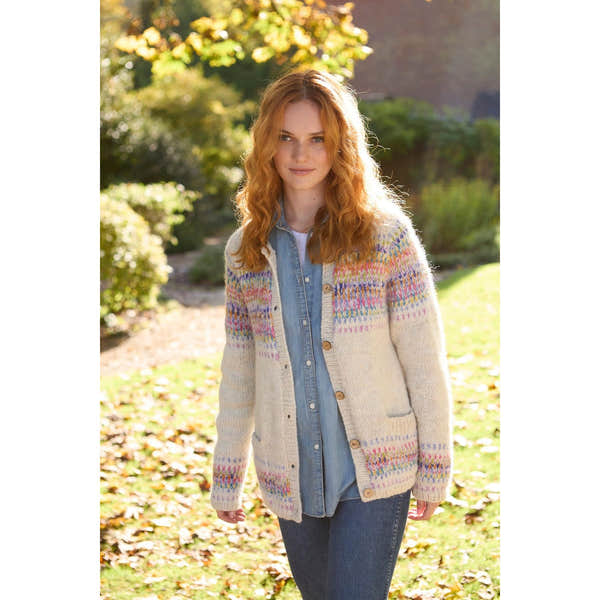 Pachamama Arundel Cardigan in Oatmeal, cozy knit sweater with colorful Fair Isle pattern, button-front, worn by a woman outdoors.