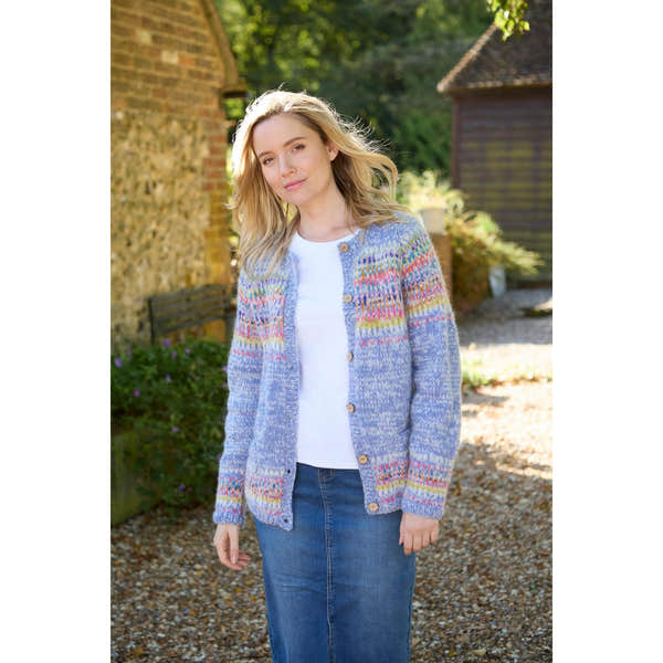 Pachamama Arundel cardigan in sky blue with colorful Fair Isle pattern, button-front, worn by a woman outdoors.