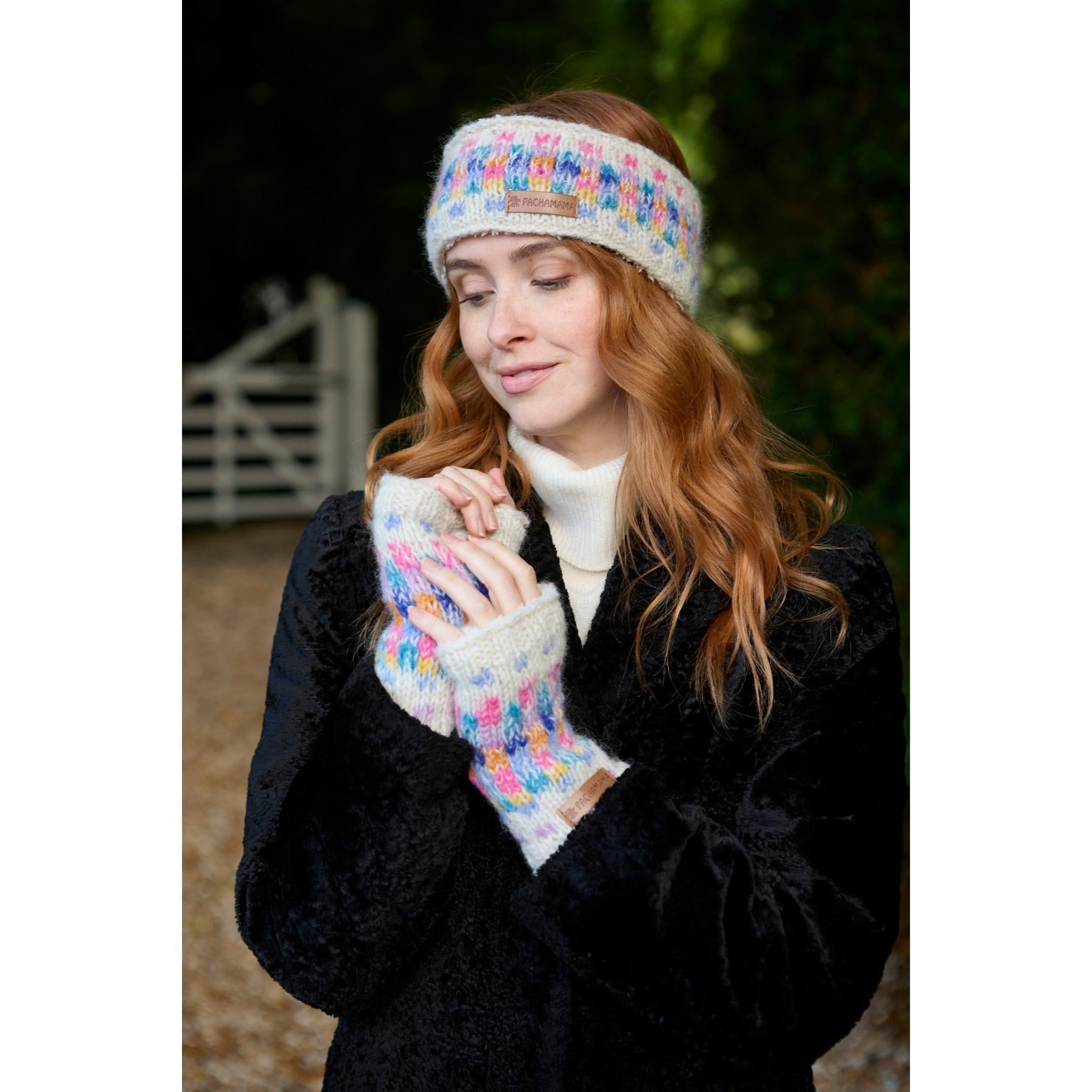 Woman wearing Pachamama Arundel handwarmer mittens and headband outdoors in fall setting.