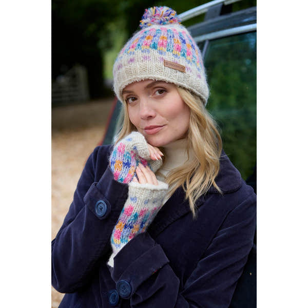 Handwarmer hat and matching gloves in oatmeal color with colorful knit accents, worn by a woman outdoors.