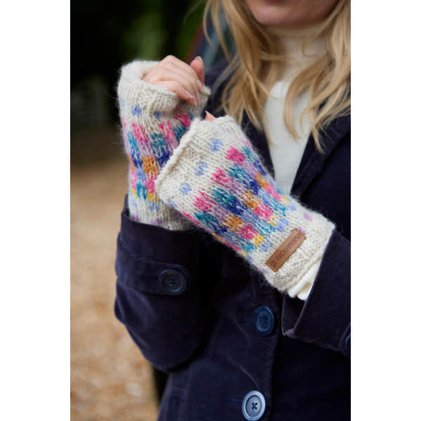 Pachamama Arundel Handwarmer Oatmeal mittens with colorful knit pattern, worn by a woman outdoors, cozy winter accessory.