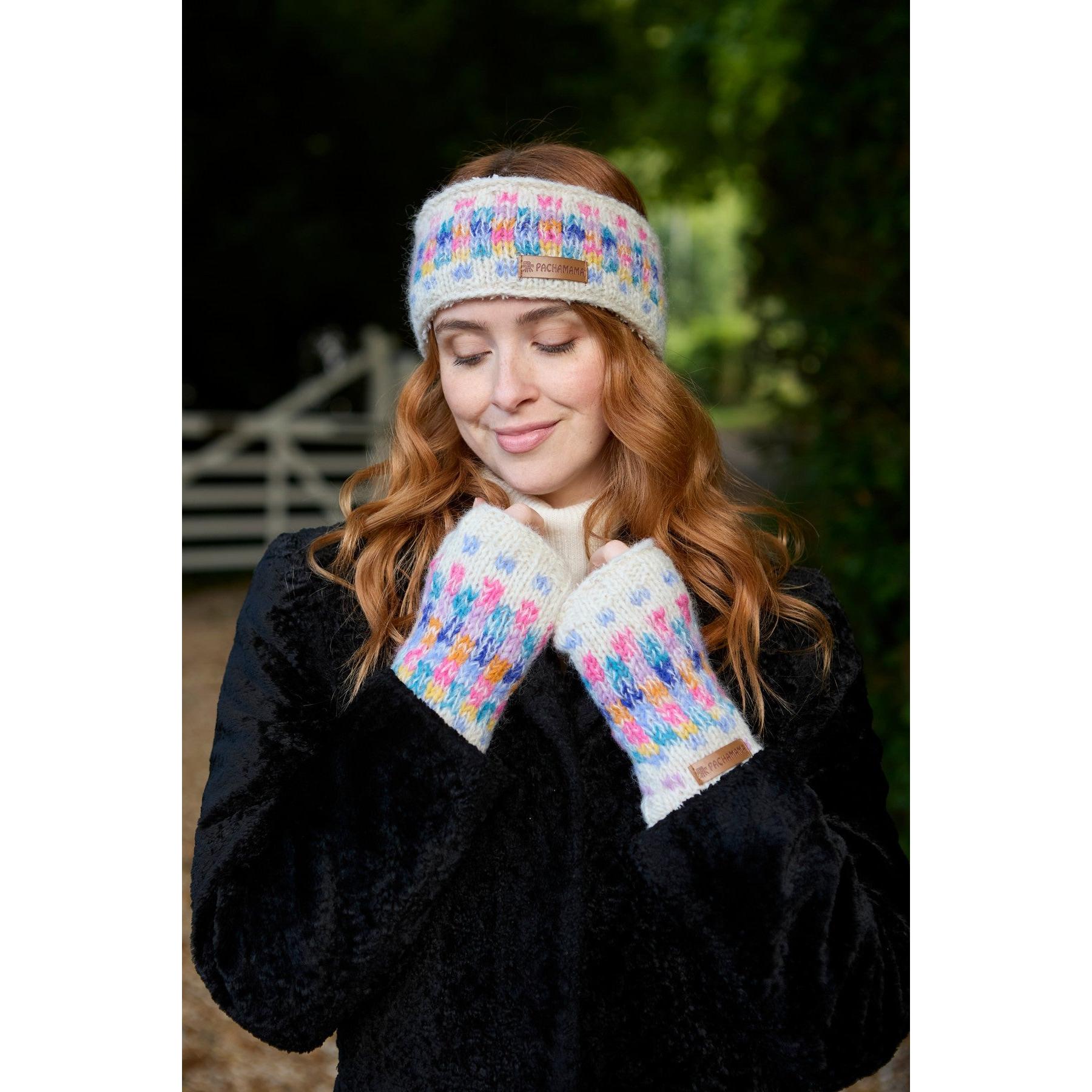 Young woman wearing Pachamama Arundel oatmeal headband and matching gloves outdoors, cozy winter accessories with colorful knit pattern.