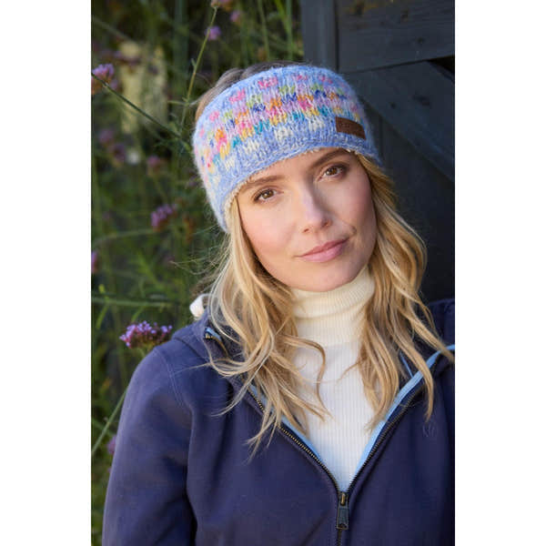 Pachamama Arundel Headband Sky, colorful knitted winter headband worn outdoors by woman, lightweight and cozy accessory.