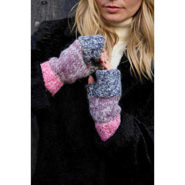 Pachamama Berlin purple handwarmer with pink and gray knit design, held by a woman wearing a black coat and cream turtleneck.