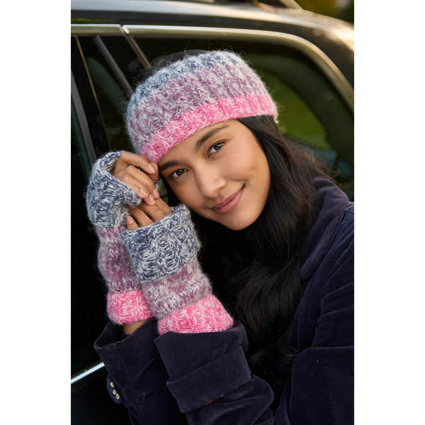 Woman wearing a purple Pachamama Berlin headband and matching fingerless gloves, smiling outdoors next to a car.