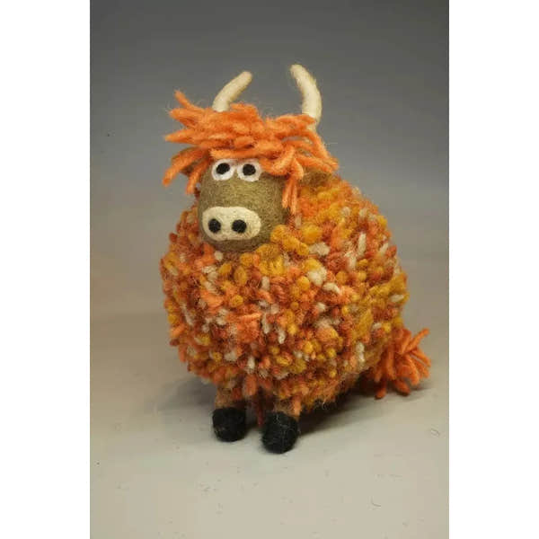 Pachamama Duncan Highland Cow plush toy with orange yarn wool, horns, and googly eyes. Soft, handmade animal figure for kids or decor.