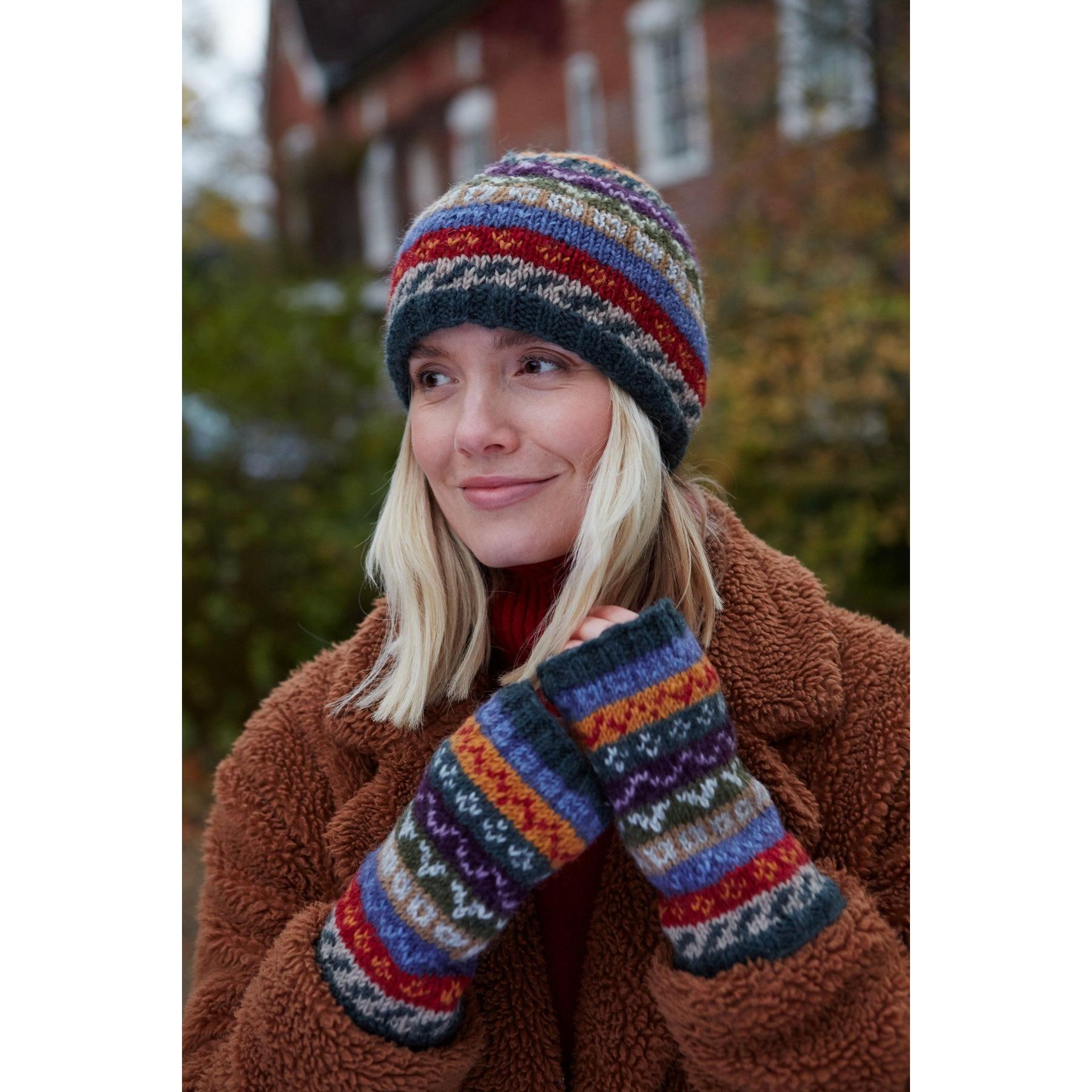 Woman wearing Pachamama Elveden beanie and matching knitted gloves outdoors in fall.