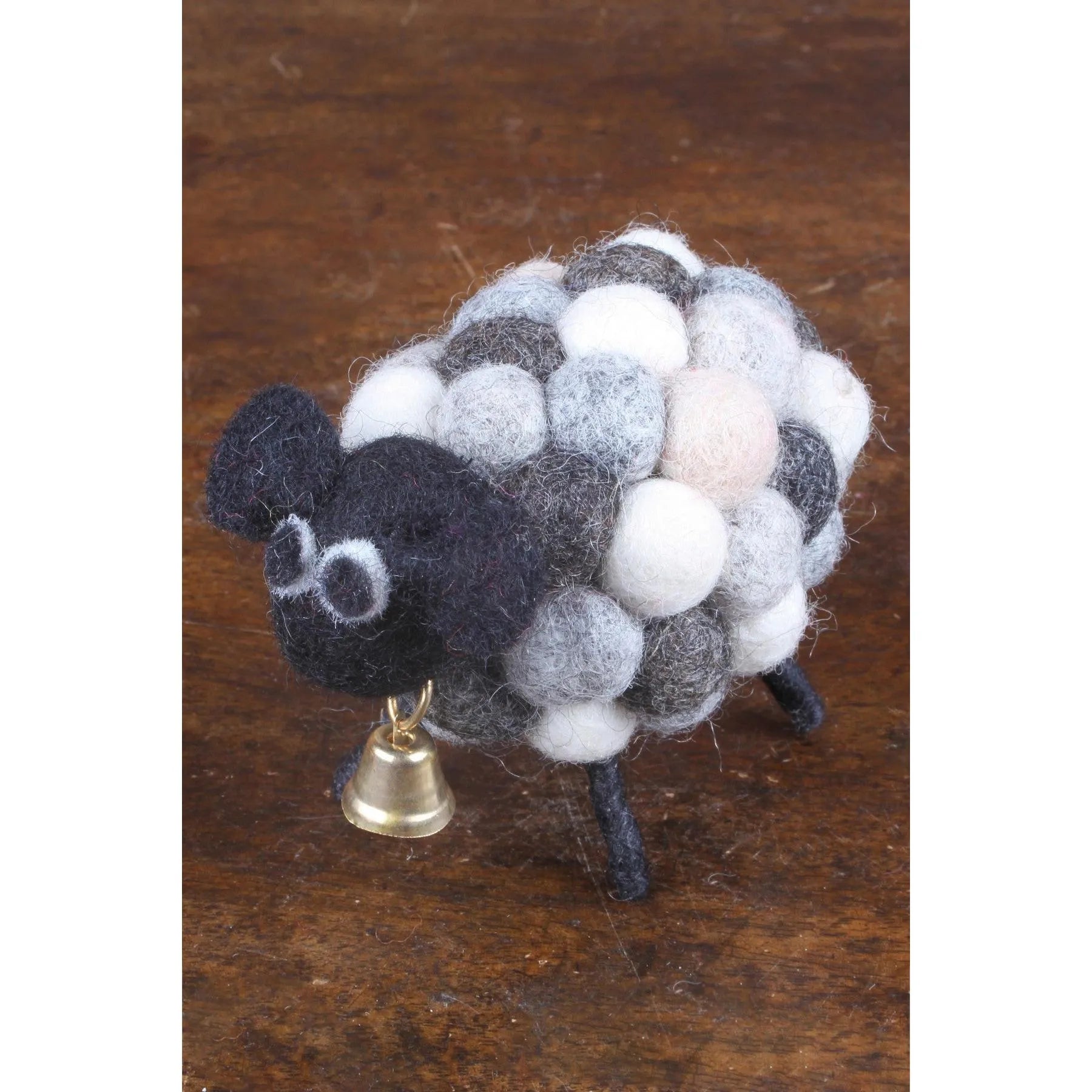 Felted lamb figurine named Pachamama Helen The Herdi Bobbly Lamb with black face, white, gray, and pink wool body, small bell, and black legs.