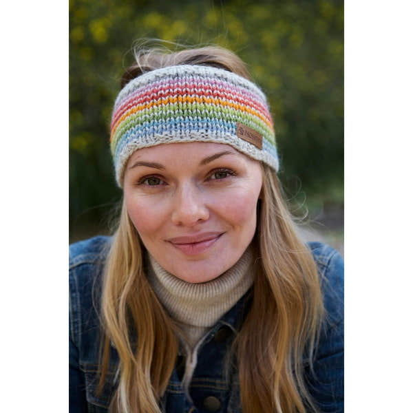 Woman wearing Pachamama Hoxton Stripe Headband in multicolor Merino wool, outdoor setting, stylish, cozy winter accessory.