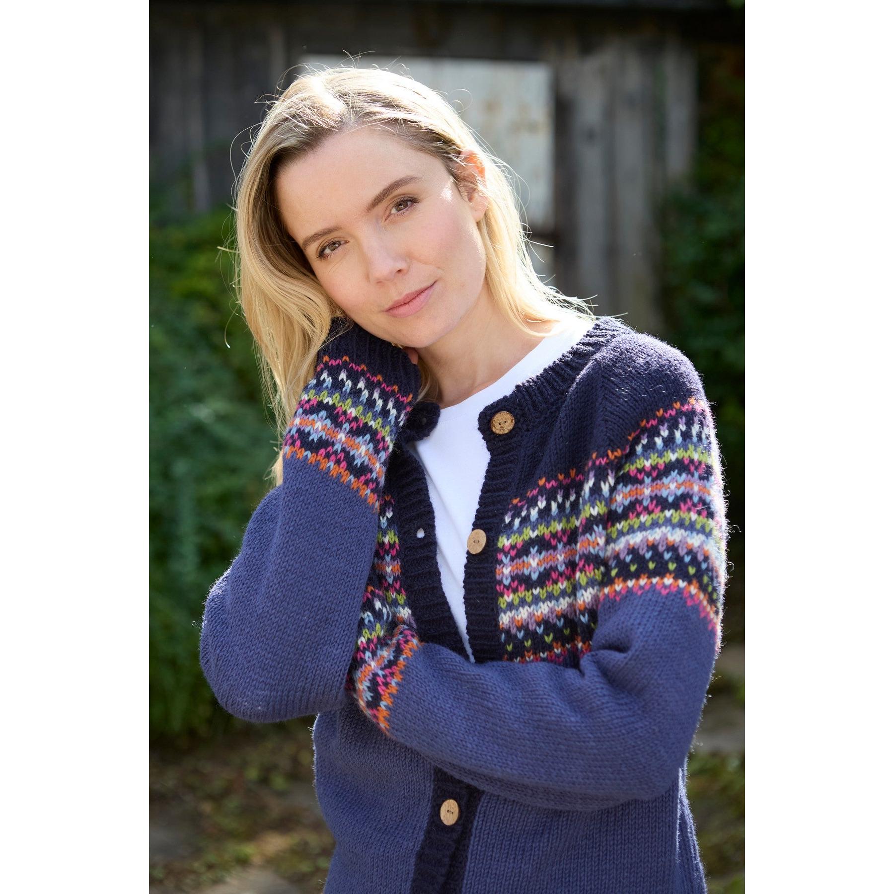Woman wearing a navy blue Pachamama Iona Cardigan Denim with colorful patterned details, outdoors in natural light.