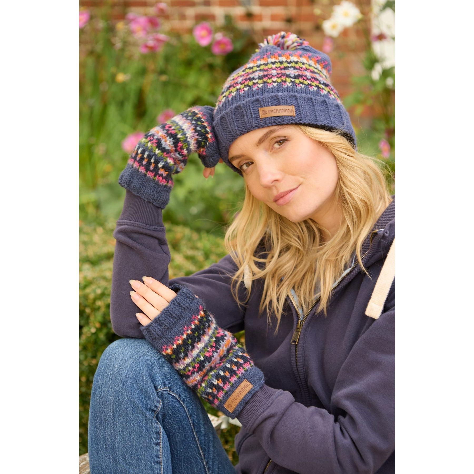Pachamama Iona Roll Back Bobble Beanie Denim with colorful patterns, knit design, and leather logo patch, worn with matching mittens.