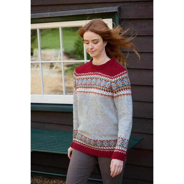 Woman wearing Pachamama Iona Sweater Burgundy with colorful fair isle pattern on upper chest and sleeves, and solid burgundy accents.