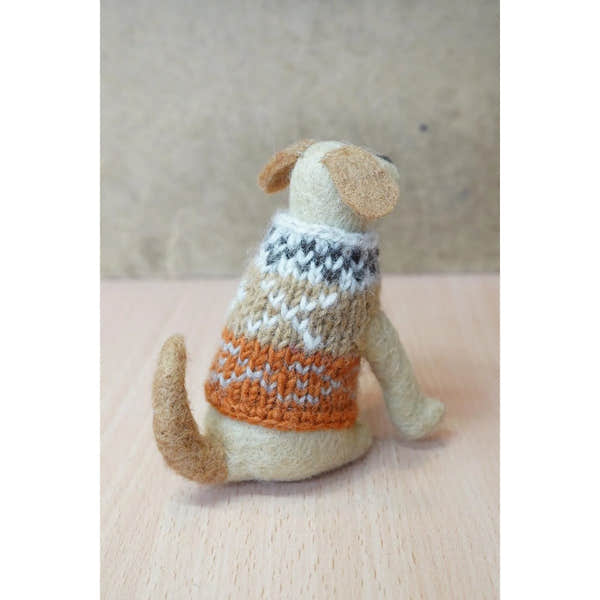 Felted Labrador dog wearing a multicolored knitted sweater, sitting on a wooden surface.