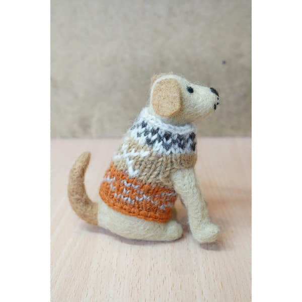 Felted Labrador dog figurine with a cozy multicolored sweater, sitting on a wooden surface.