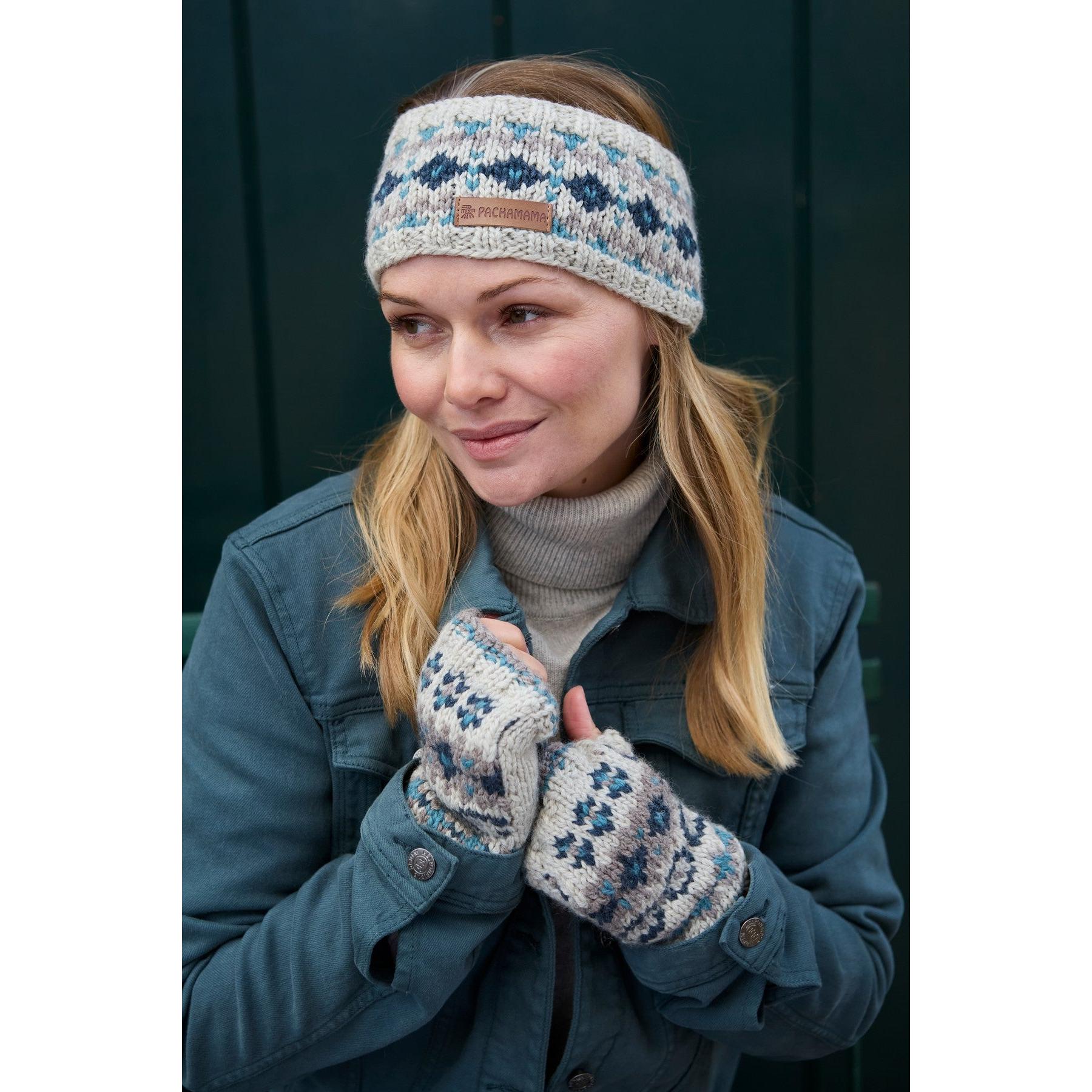 Woman wearing blue Pachamama Loch Fyne Merino headband and matching fingerless gloves, outdoors.