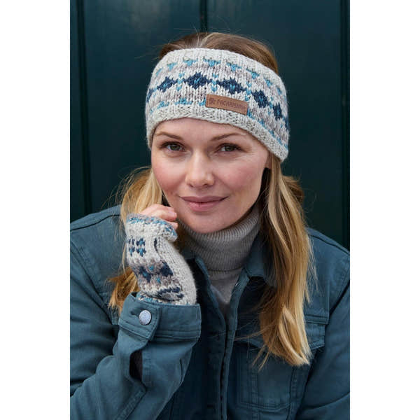Woman wearing blue Pachamama Loch Fyne Pure Merino headband and matching gloves, outdoor fashion accessory.