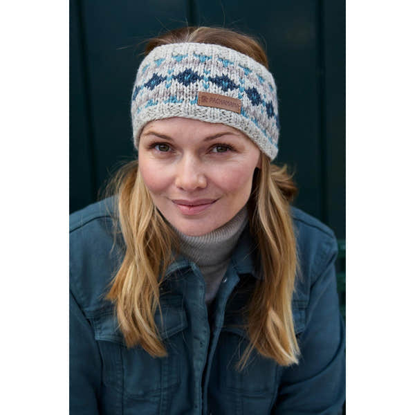 Woman wearing Pachamama Loch Fyne pure merino blue headband with colorful pattern and leather logo patch.