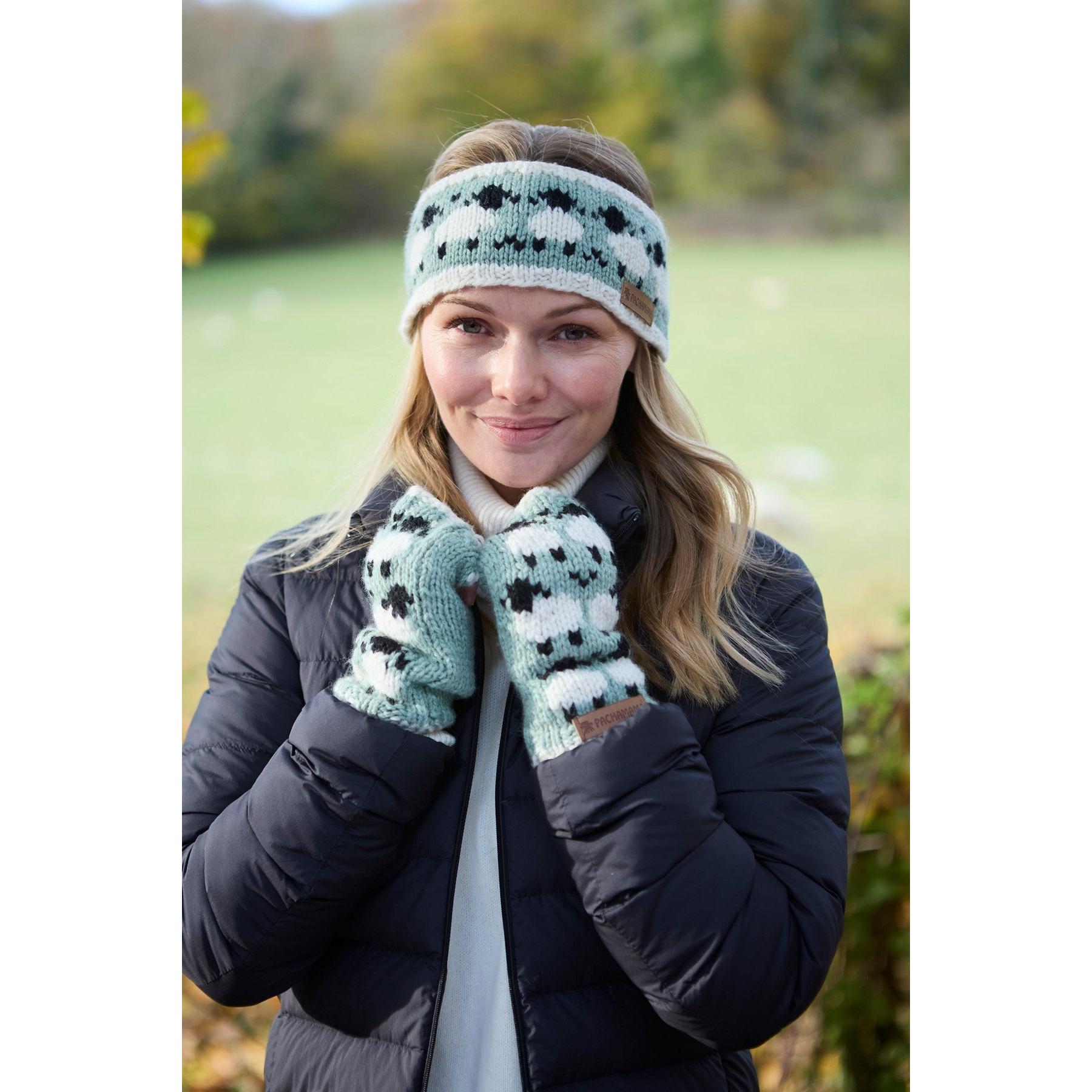 Woman wearing green Pachamama Merino sheep knit headband and mittens outdoors in fall.