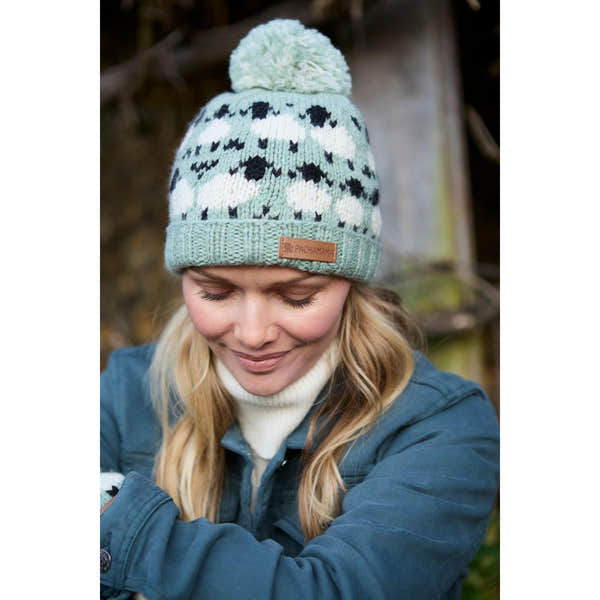 Green Pachamama Merino sheep roll-back beanie with pom-pom, made for warmth and style.