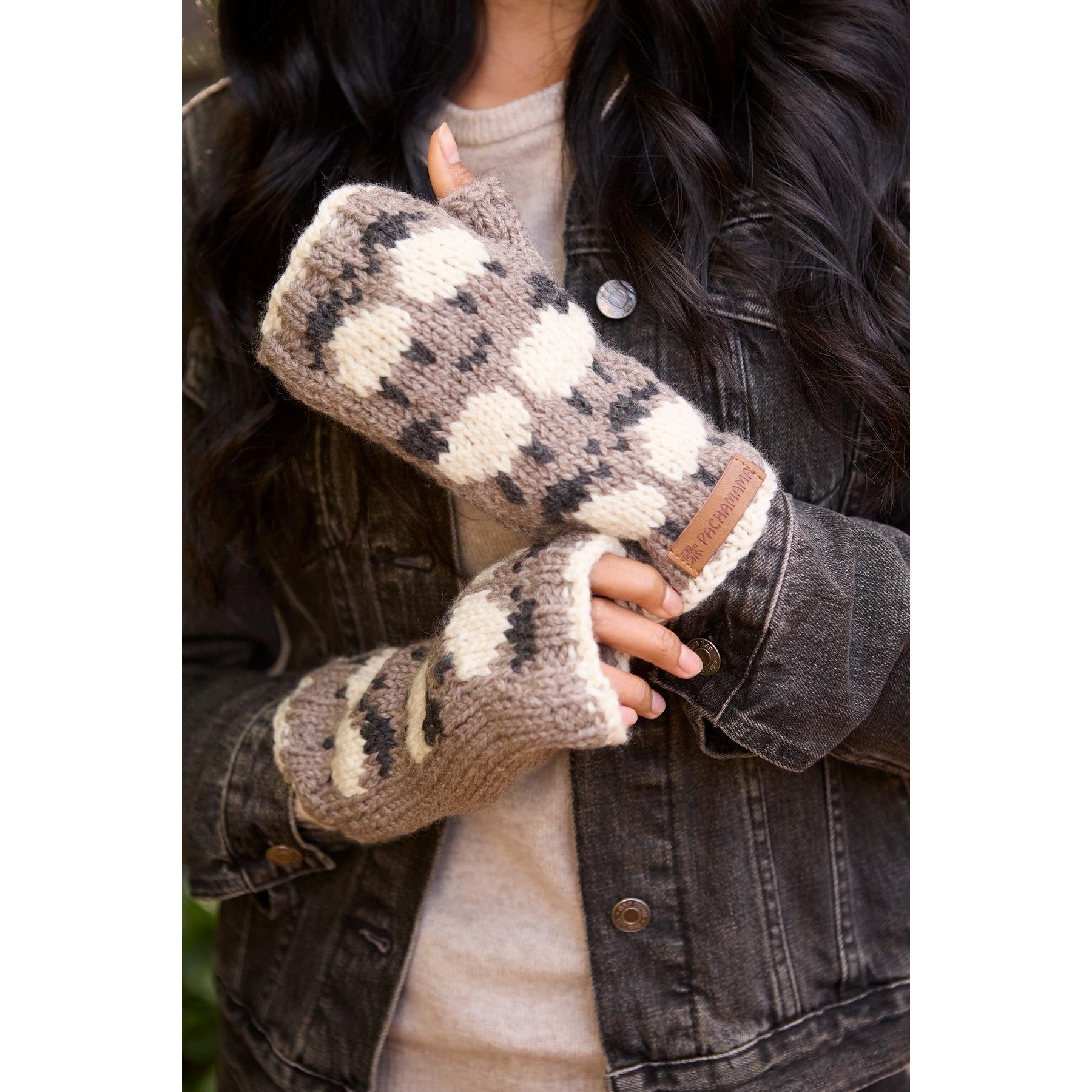 Pachamama Merino sheep handwarmer mushroom-patterned knitted glove worn by a person with a denim jacket.
