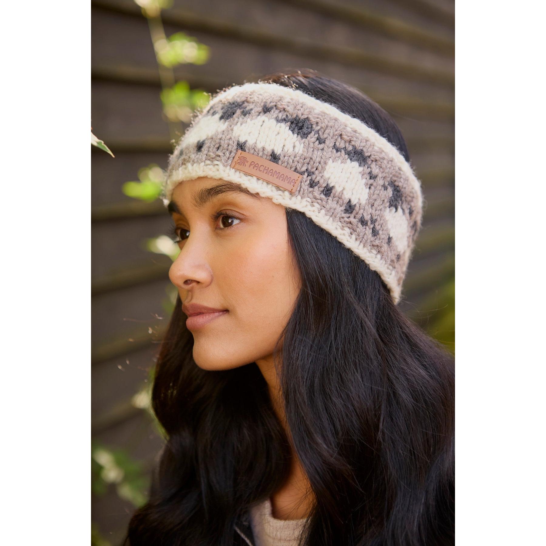 Pachamama Merino sheep headband with mushroom pattern and leather logo tag, worn by woman outdoors.