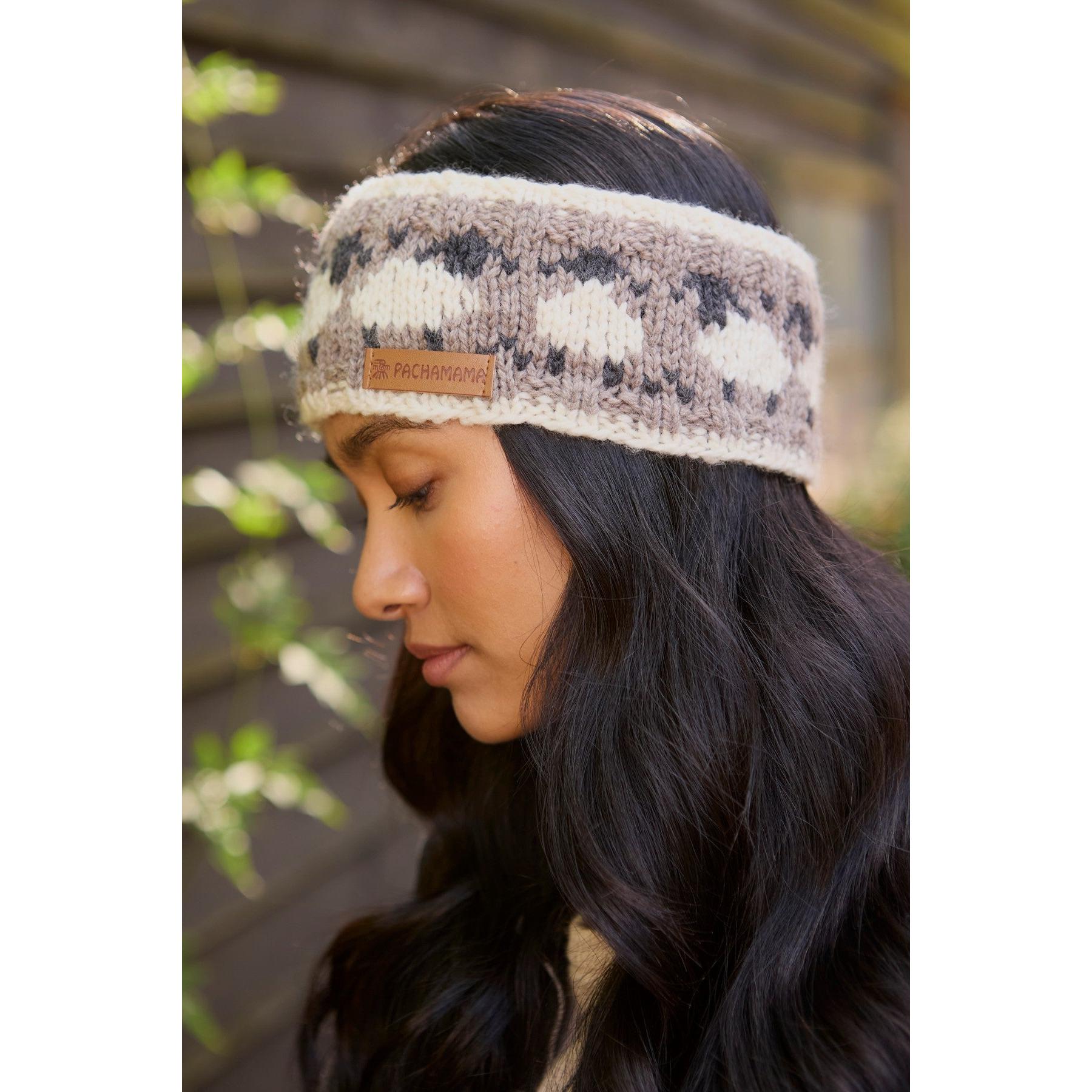 Pachamama Merino sheep headband with mushroom pattern, soft knitted wool, and leather logo patch worn by a woman outdoors.