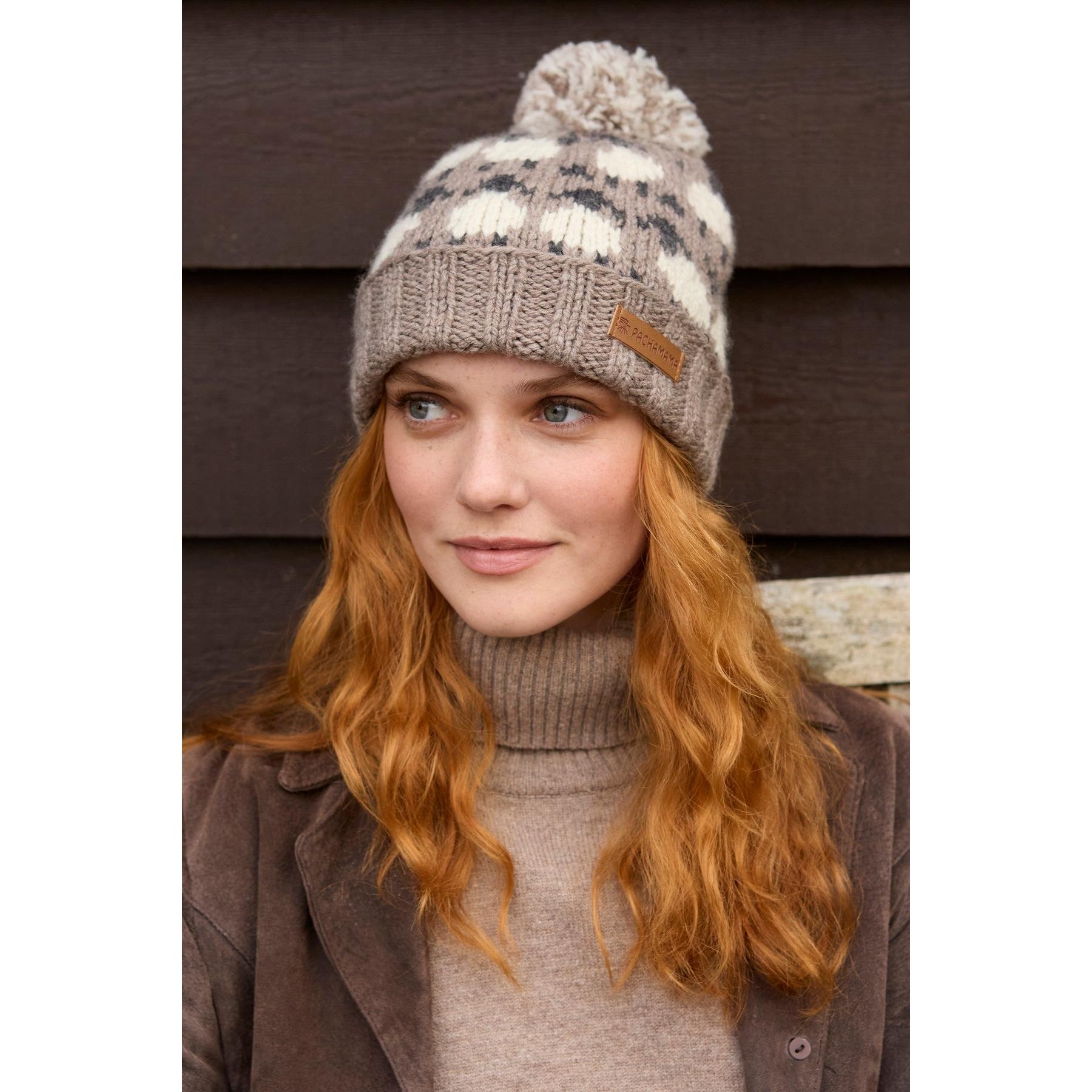 Women wearing beige knit beanie with pom-pom, floral pattern, and 