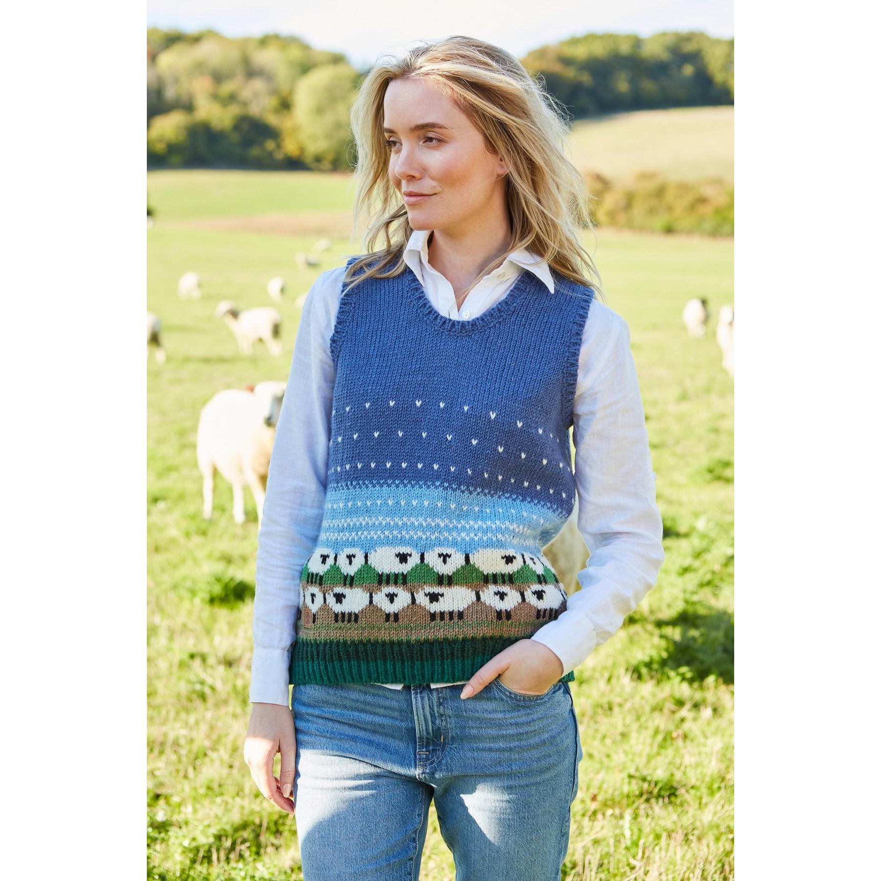 Pachamama Snowy Sheep knitted tank top featuring a blue gradient design, sheep pattern, and sheep motif at the bottom, worn over a white collared shirt.