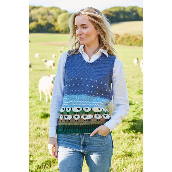 Pachamama Snowy Sheep knitted tank top featuring a blue gradient design, sheep pattern, and sheep motif at the bottom, worn over a white collared shirt.